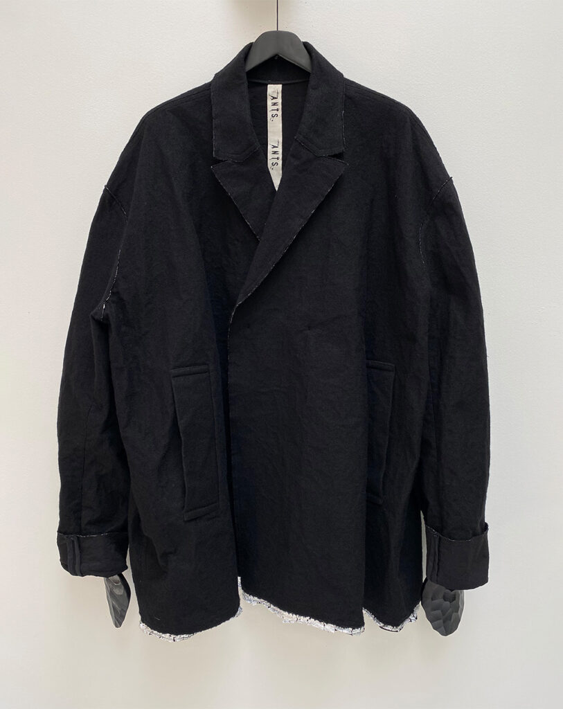 Frontside of oversized double breasted jacket in bonded wool and aluminium fabric