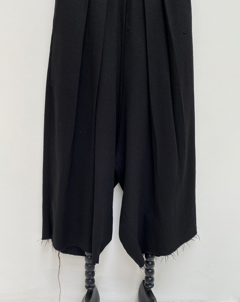 close up of unisex oversized light woolen black pants with double pleats at the waistband