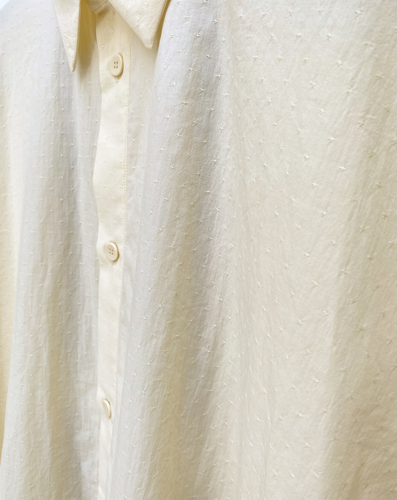 close up front closure of ANTS. oversized kimono shirt in light yellow cotton fabric