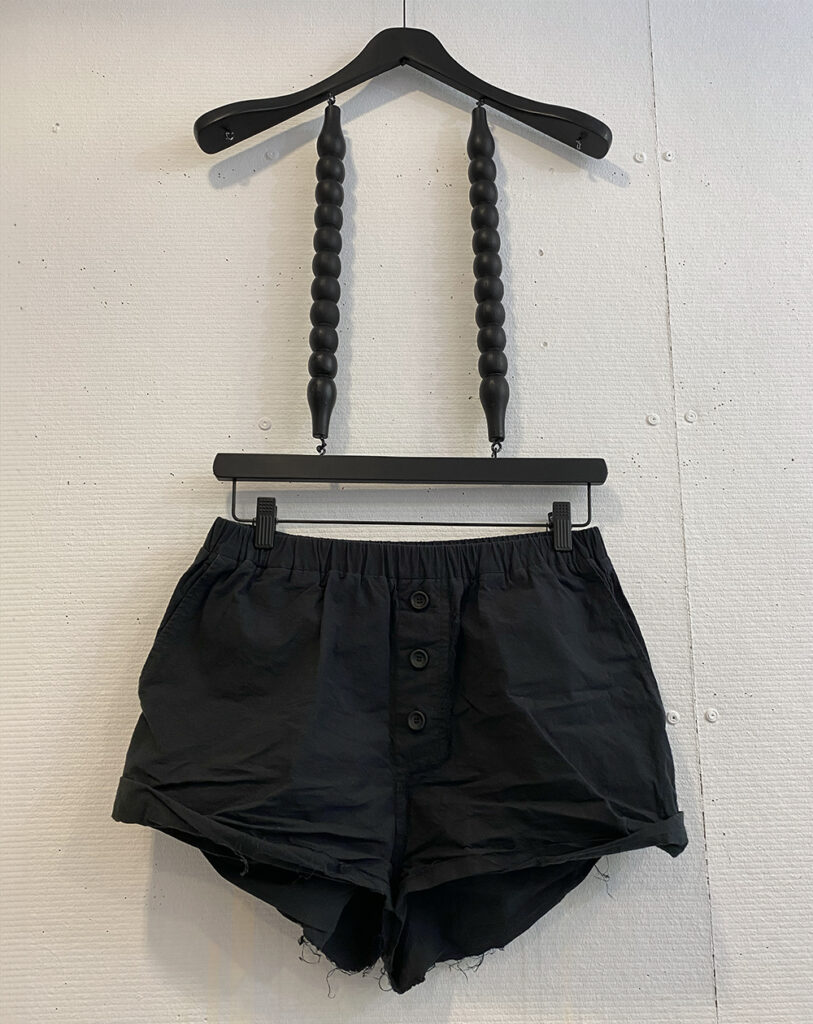 Washed cotton black shorts with fake button closure and raw edge hem and elastic waistband