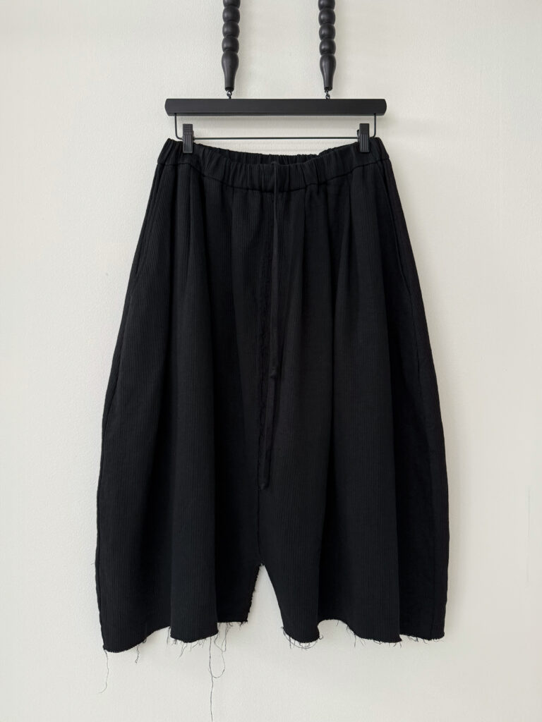 Round shaped culottes with multiple waistband pleats made in black Japanese linen corduroy fabric