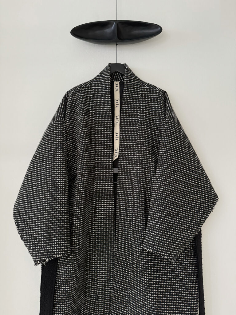 Close up of frontside of oversized kimono style wool coat with extra long belt