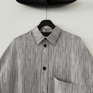Close up of collar of oversized farmer's shirt in organic cotton jacquard light stripe