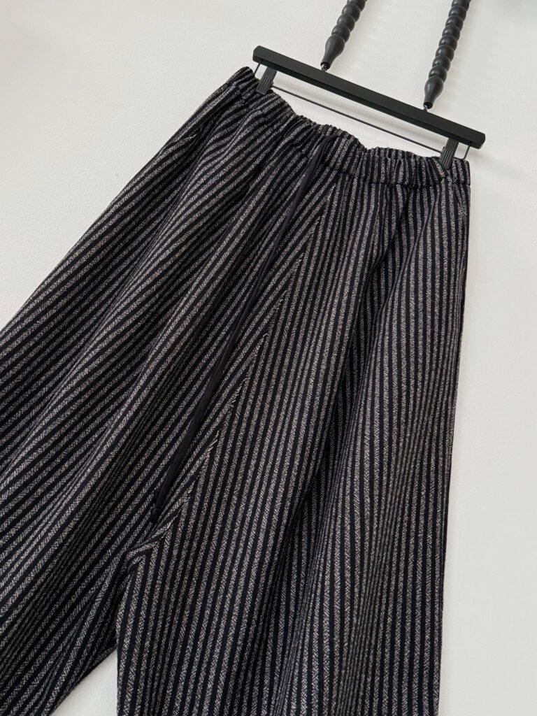 Close up of waistband with drawcord of oversized cropped pants in wool melange stripe